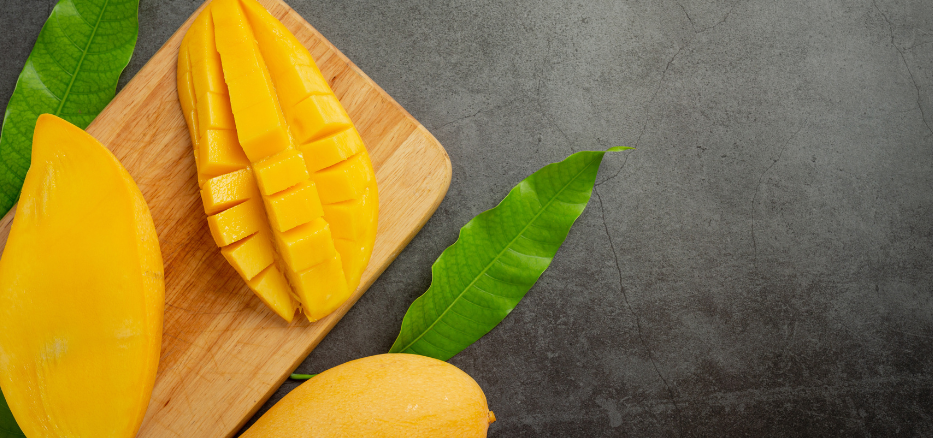 Färsk mango på en mörk skärbräda